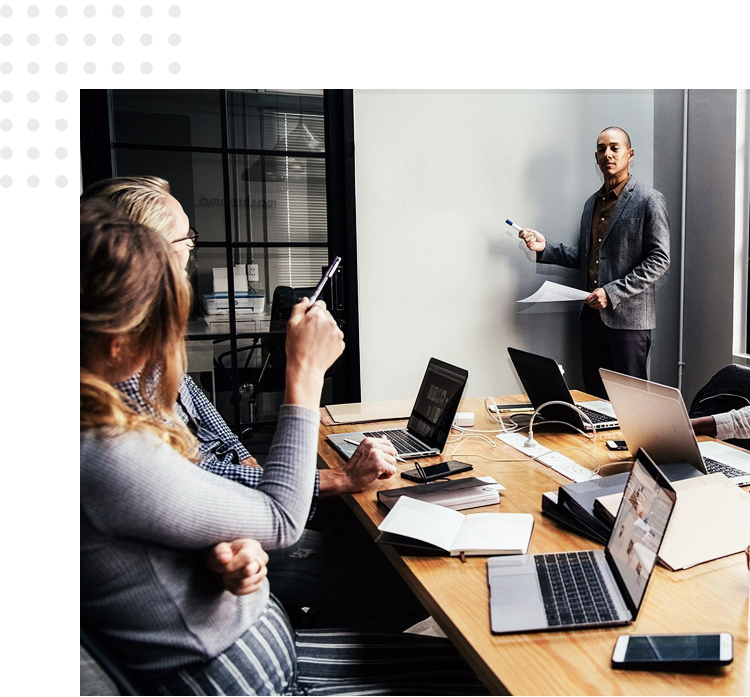 A man and woman are sitting at a table with laptops.